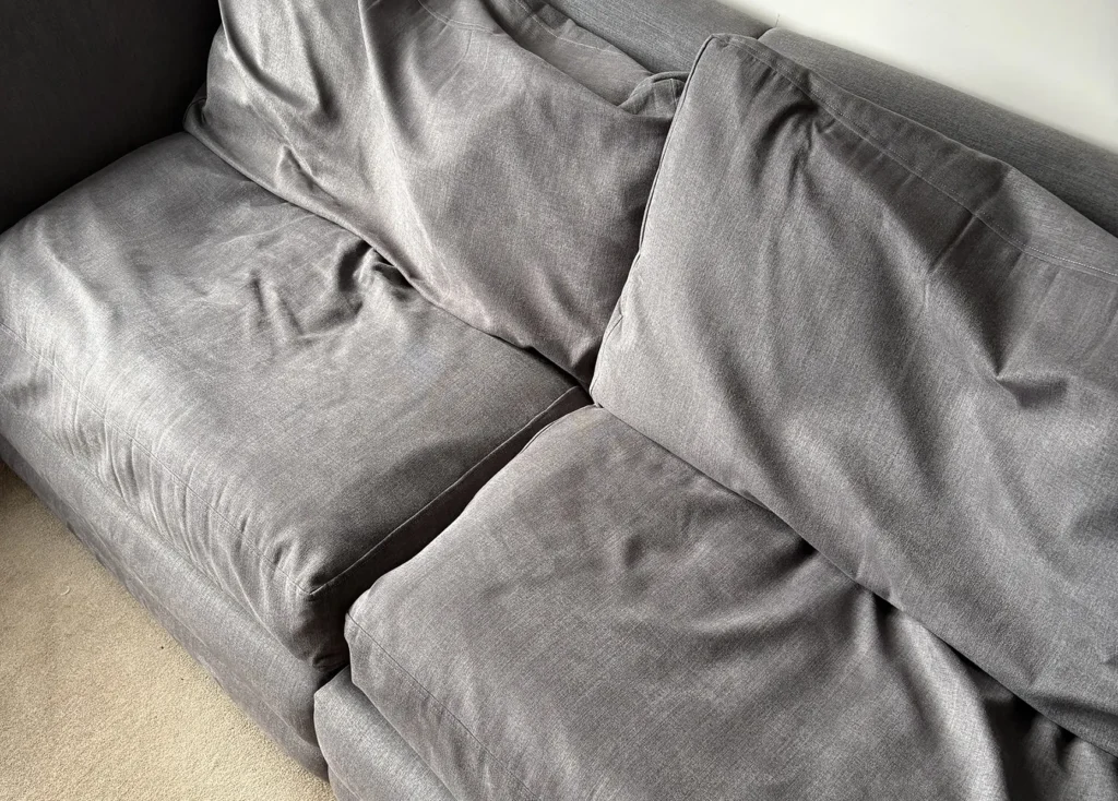 A worn sofa in Burton upon Trent with visibly sagging seat and back cushions before replacement